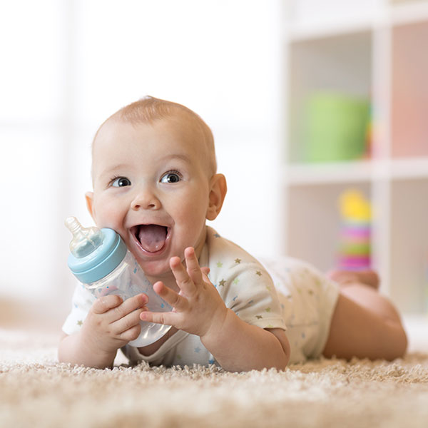 Baby on the floor with a bottle